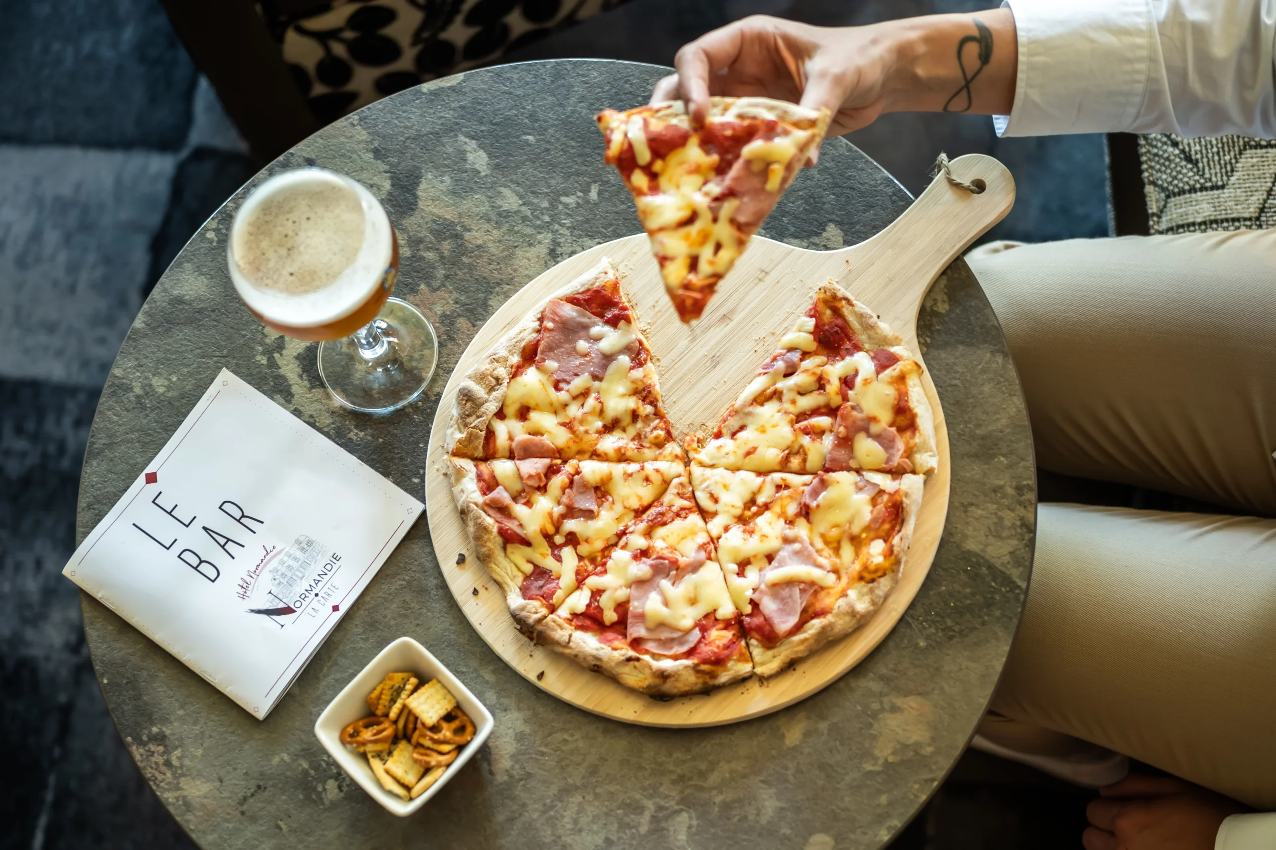Pizza avec fromage et jambon, bière, snacks.