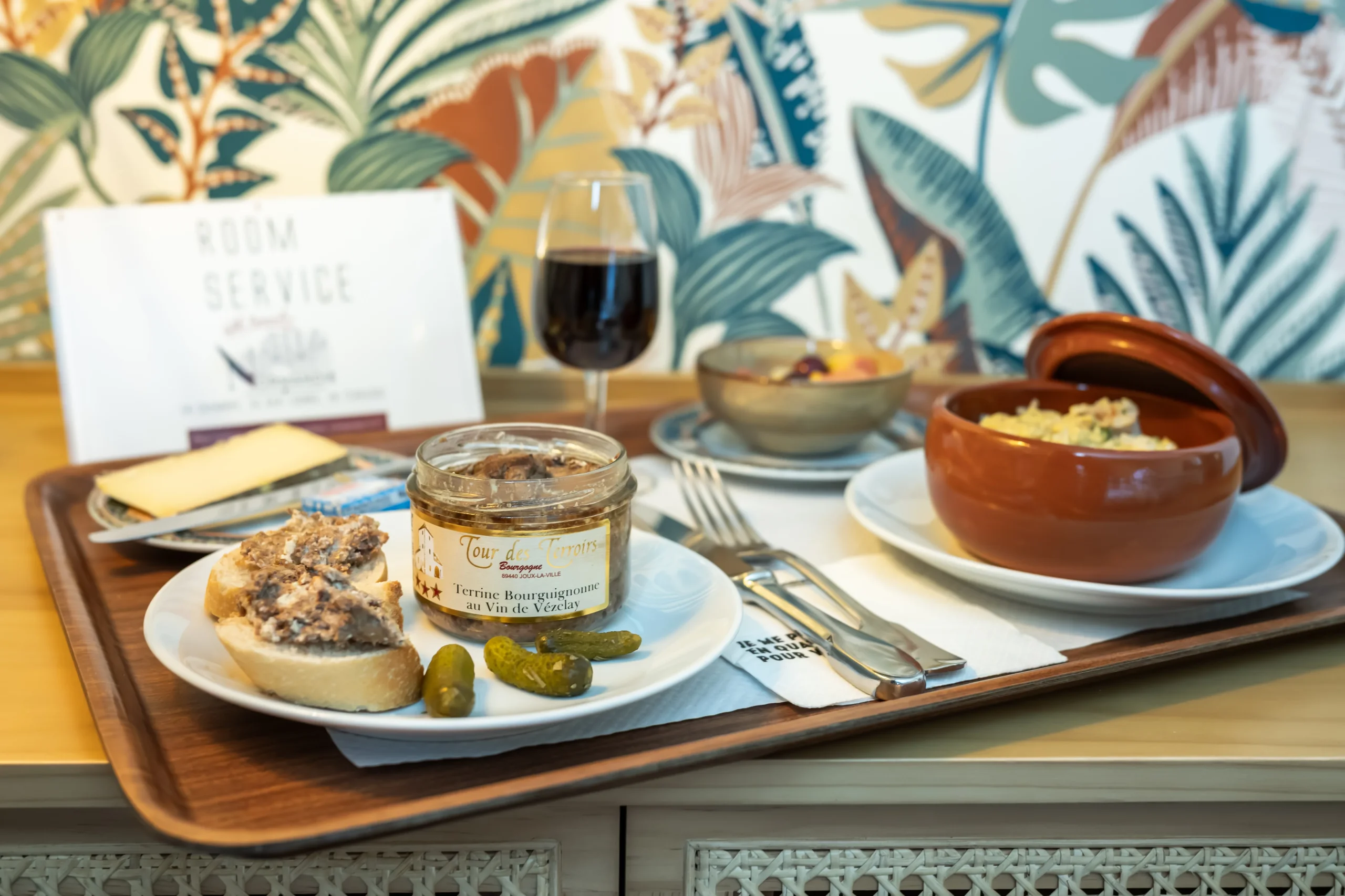 Repas de room service avec verrine et vin rouge.